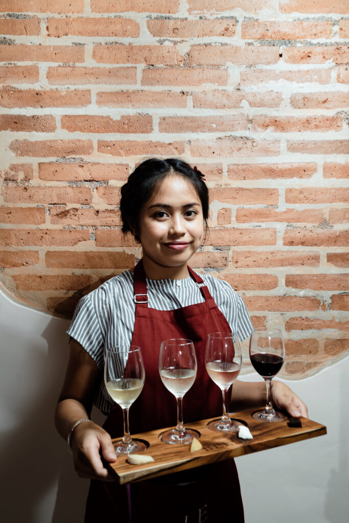 A Balinese lady holding wine flights in Bali