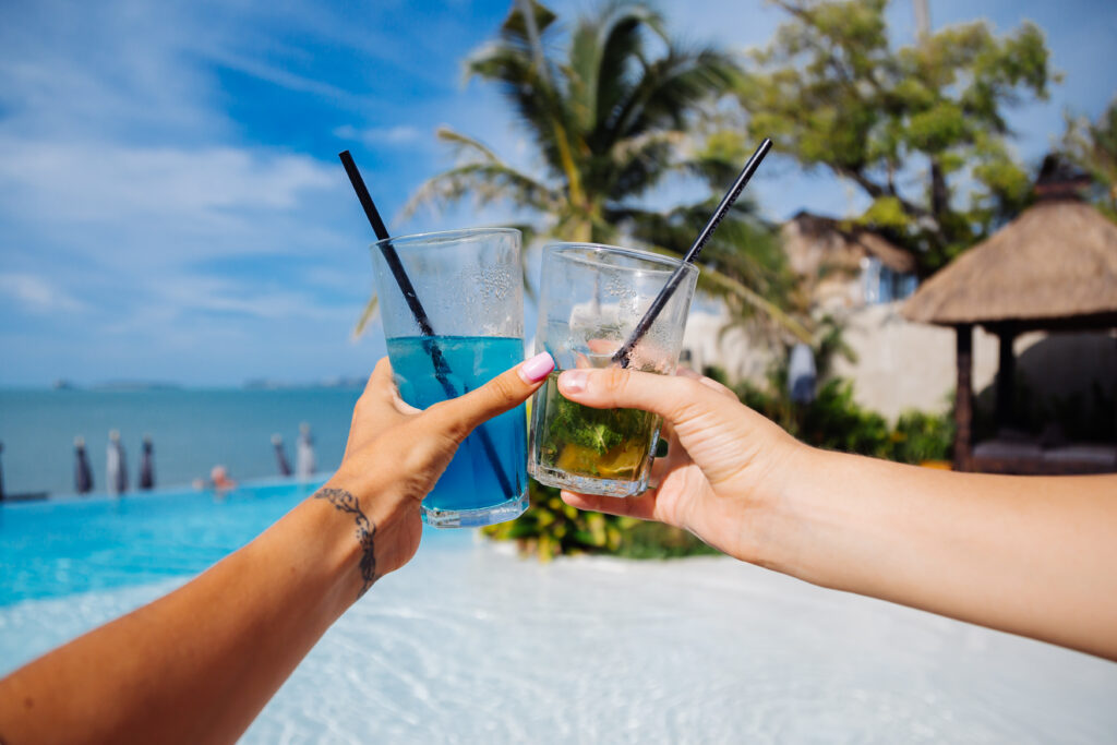 Two hands holding drinks in Bali