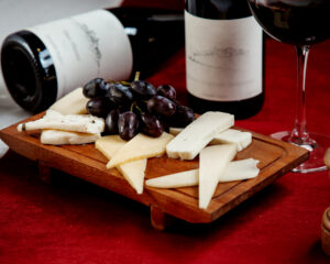 Two bottles of wine with various cheese and grapes