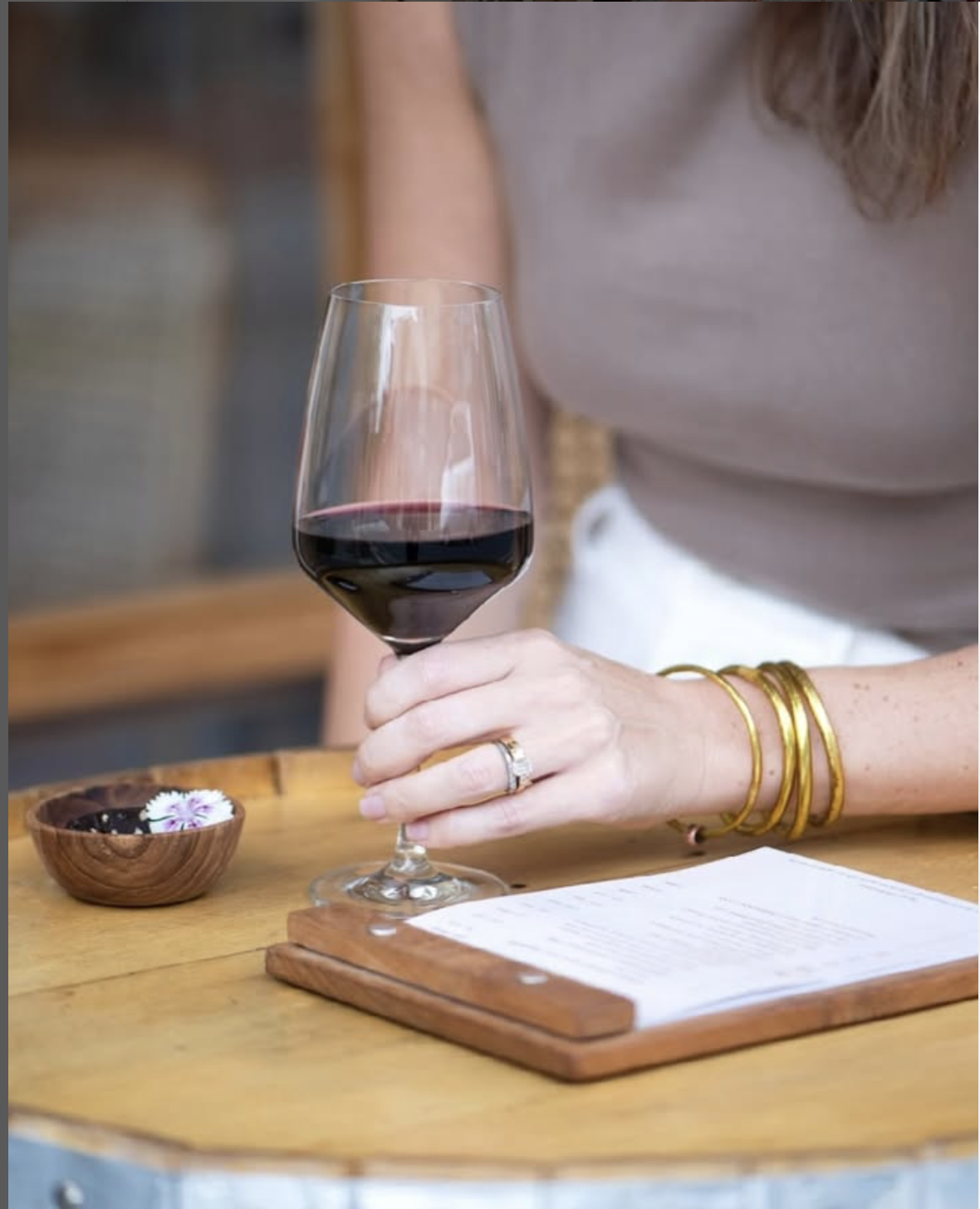 A woman holding a glass of red wine