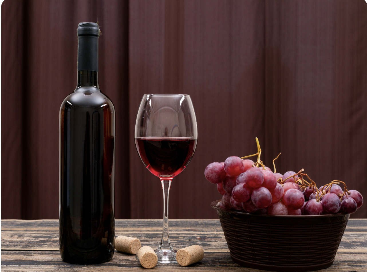 A glass of red wine next to a bottle of red wine