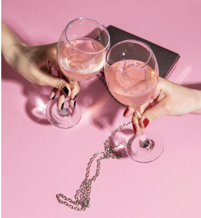 Two woman hands holding glasses of wine