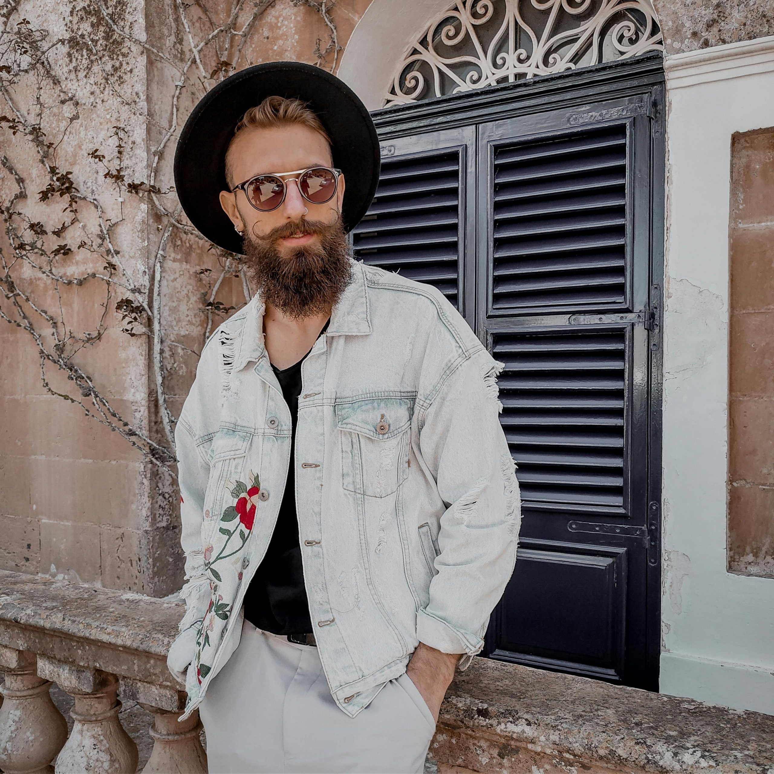 A man wearing hipster attire with denim and hat