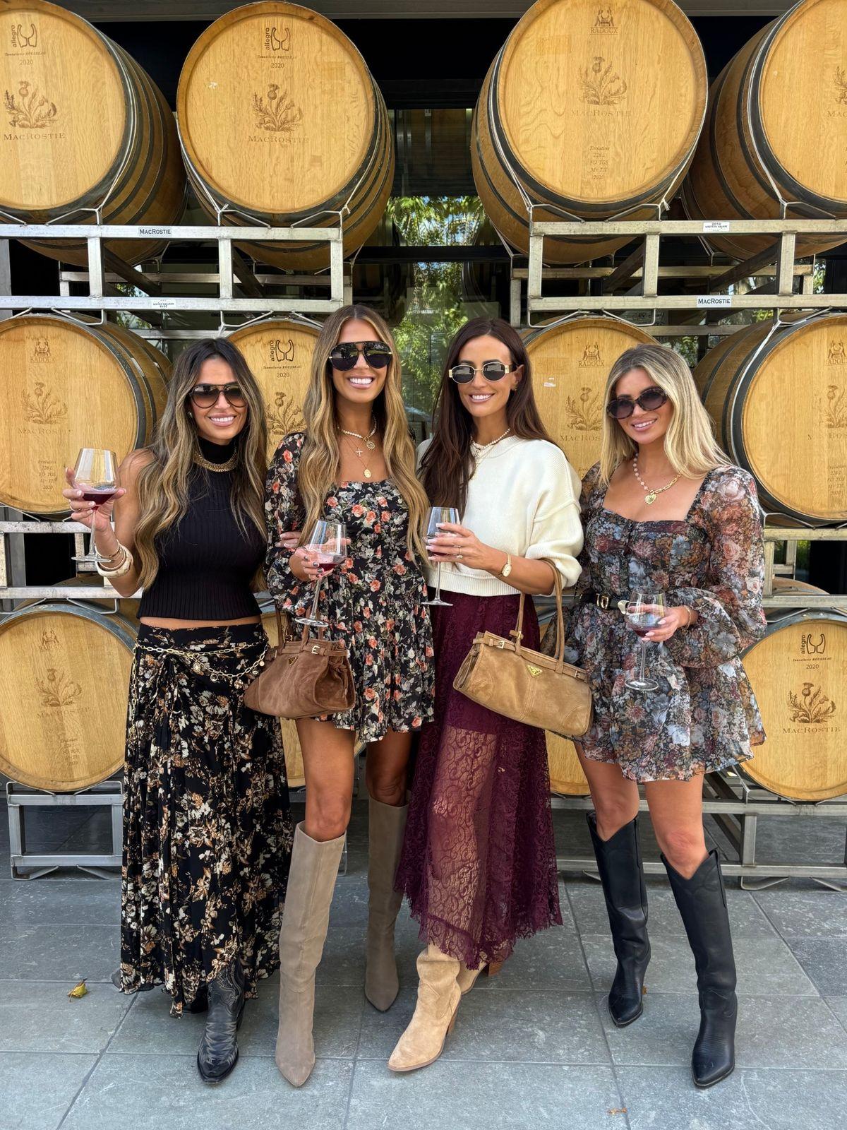 Four women wearing fashionable outfits to a winery