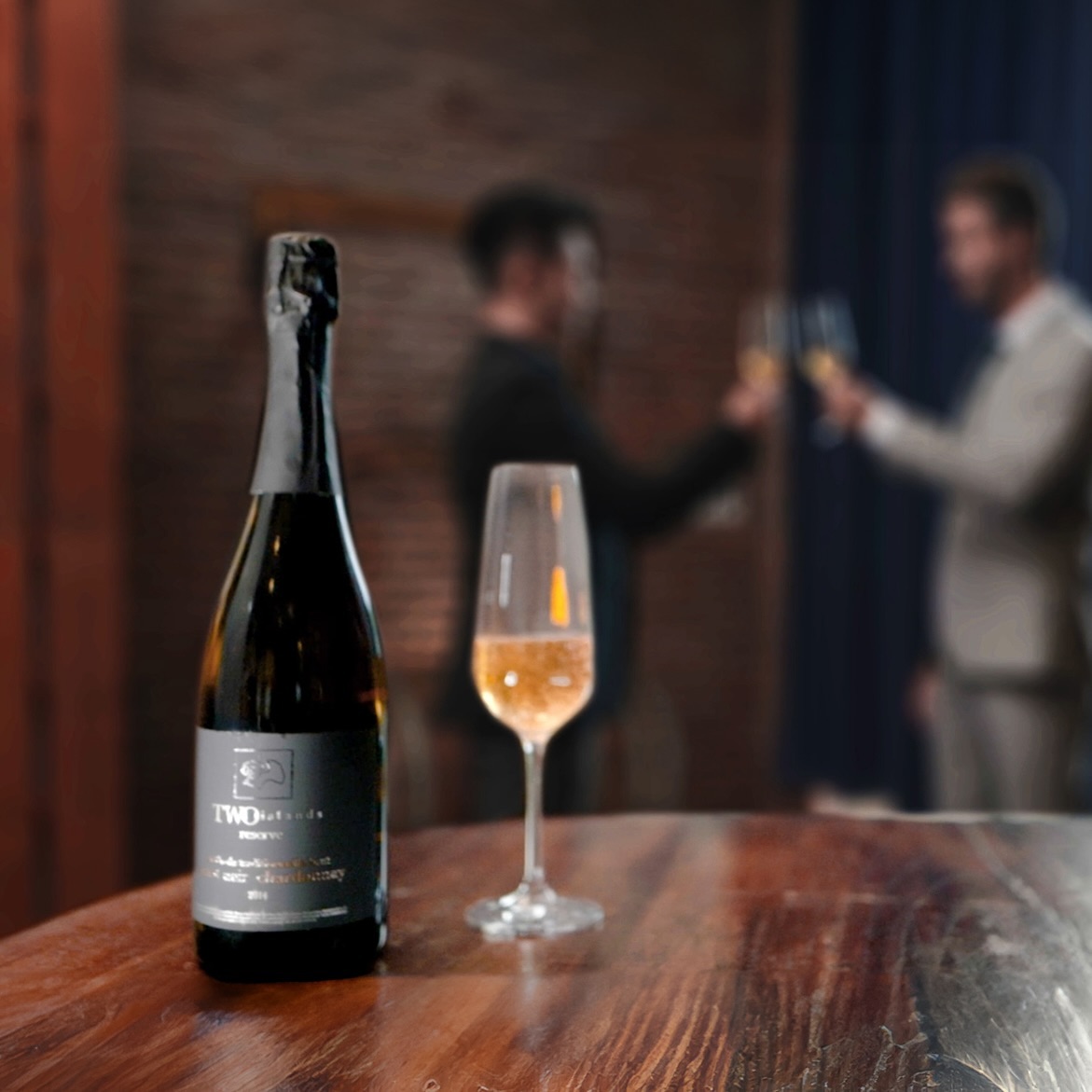 A bottle of wine sitting next to a glass of wine from Two Islands Winery in Bali