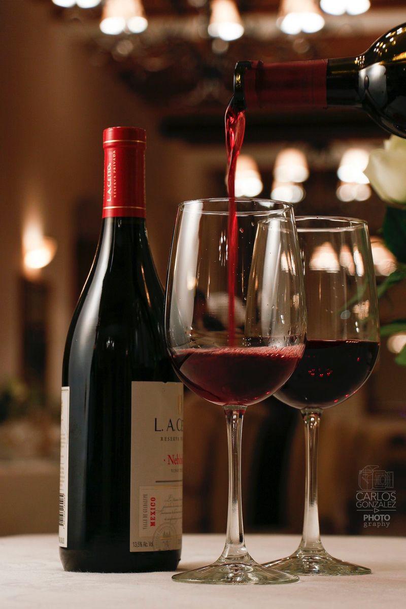 Two glasses of red wine next to a bottle of wine