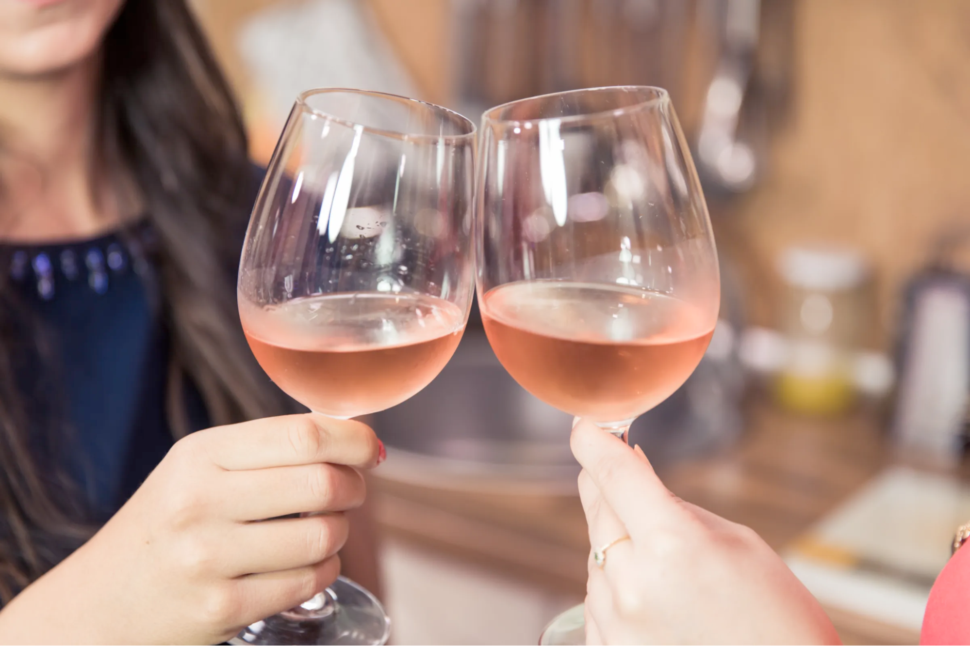 Two glasses of rose wine being clinked together
