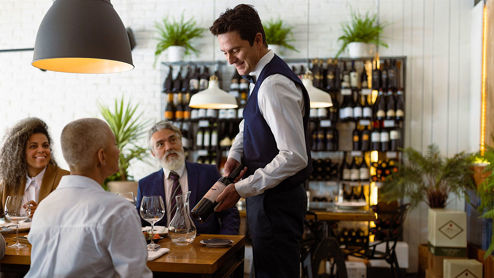 A server at a wine bar attending to customers