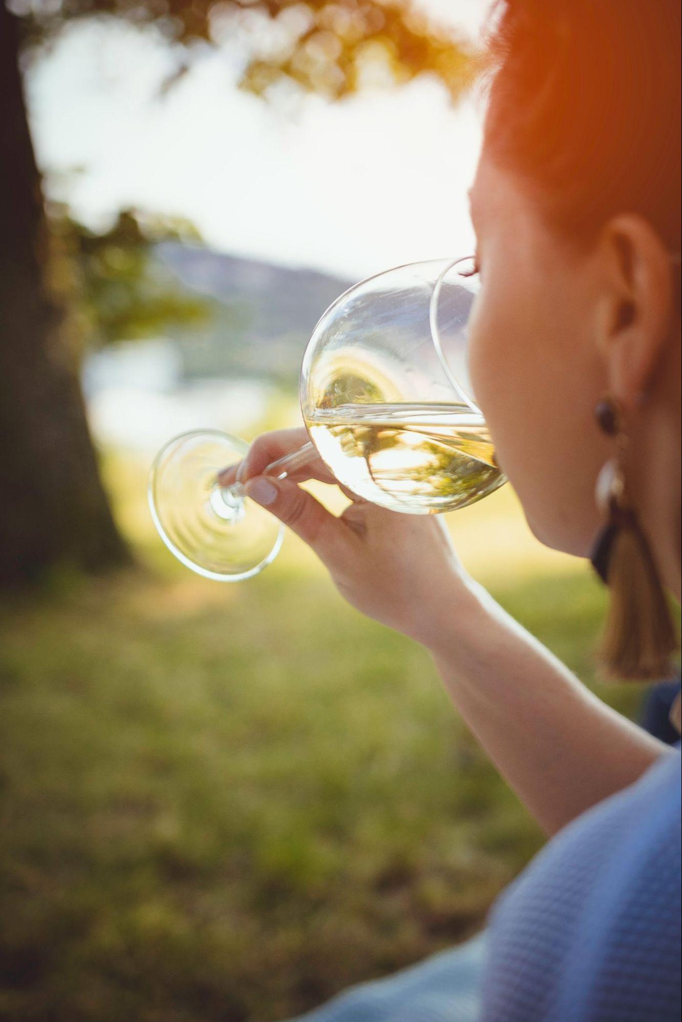 A woman tasting a glass of white wine